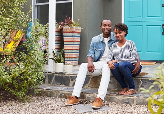 couple sitting on the porch in front of their house